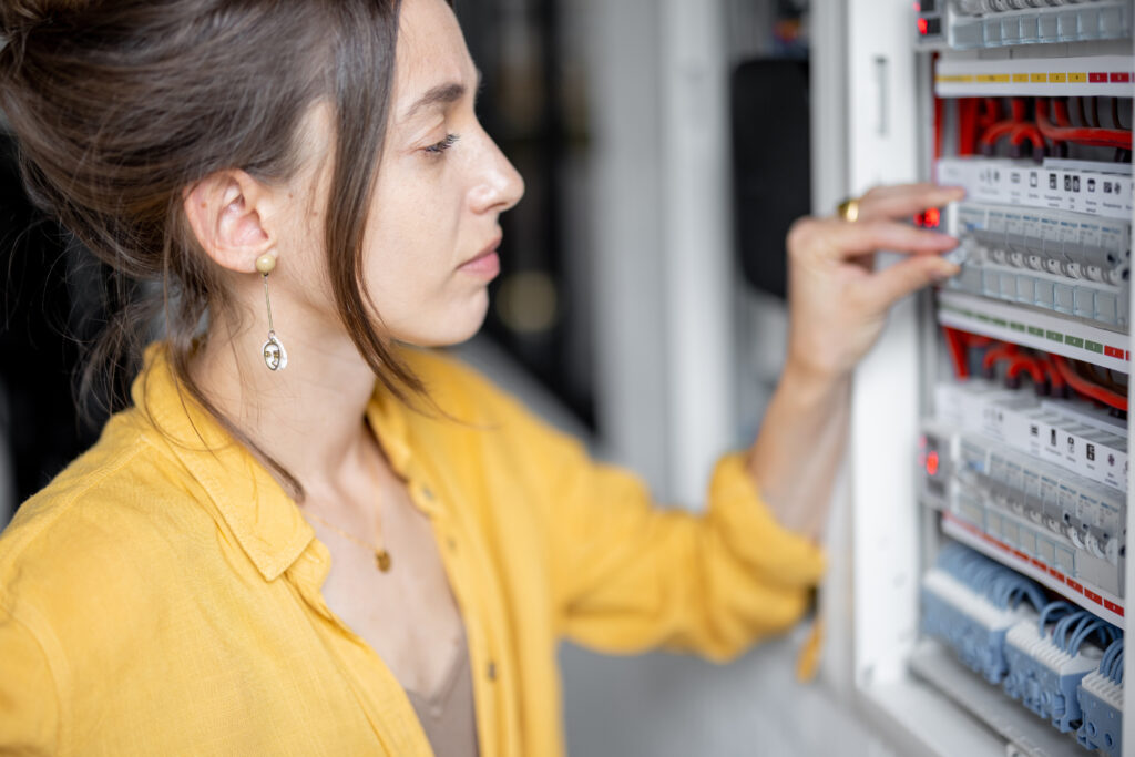 Confused woman having problems with electricity at home tinkering with a Main Electrical Panel.