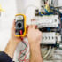 Individual testing the voltage of a circuit breaker at a fuse box. Certified Electrical Inspections