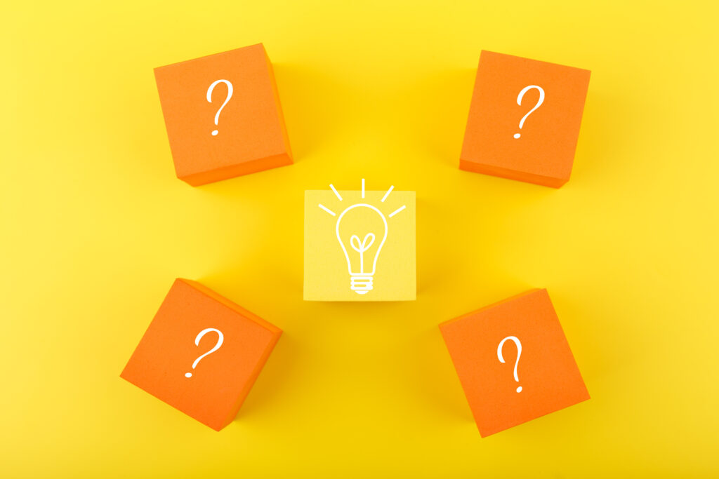 Concept of idea, creativity, start up or brainstorming. Flat lay with light bulb drawn on yellow cube and question signs on orange cubes against yellow background. Main Electrical Panel